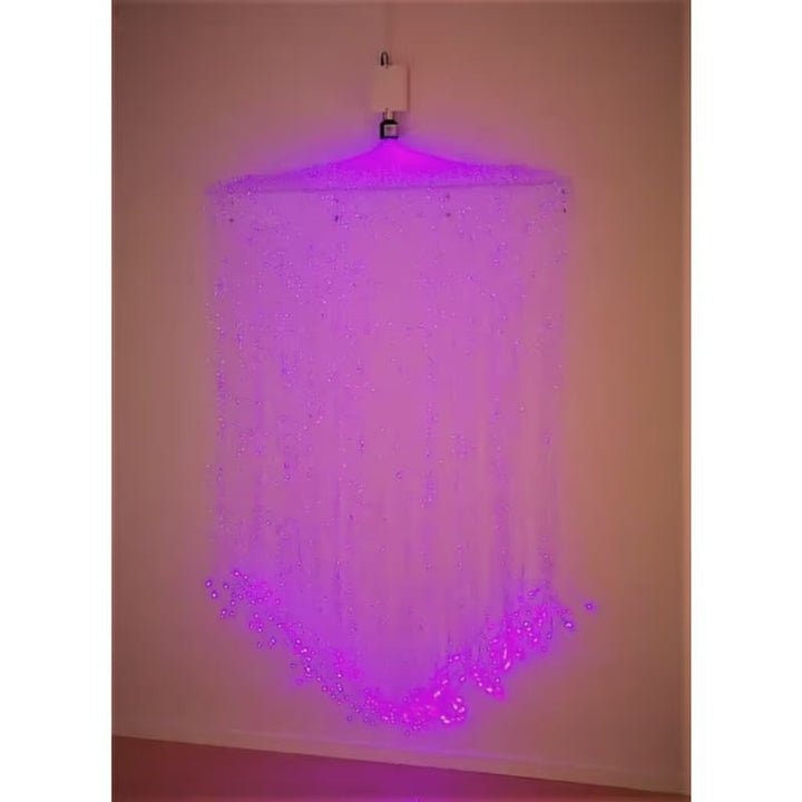 TFH Fibre Optic Curtain Wall Mount hanging in purple light, a wall mounted sensory light for calm corners and therapy rooms