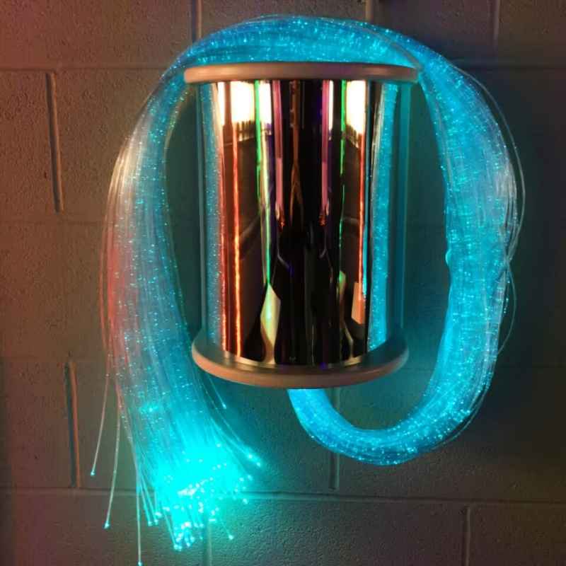 TFH Fibre Optic Wall Sconce mounted on a wall, mirrored cover reflecting glowing teal fiber optic tails for sensory room visual stimulation