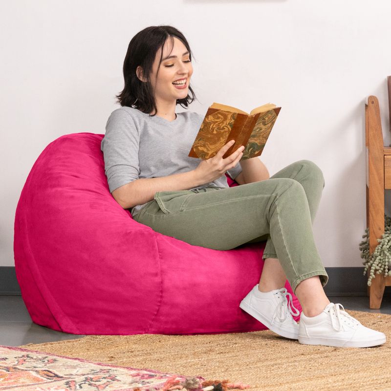 Woman enjoying a book in a Fuchsia microsuede Jaxx Saxx 3ft foam bean bag chair, bright round seating for reading nooks