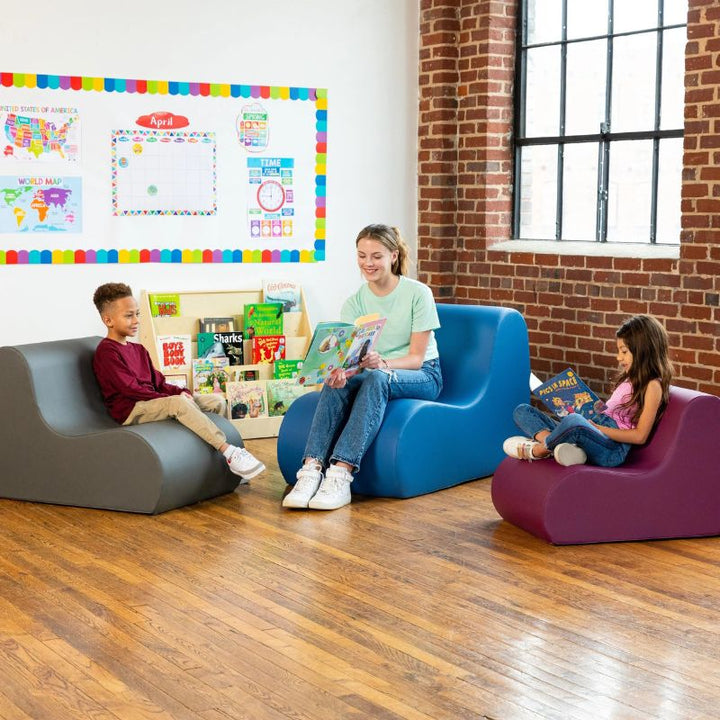 Children and a teacher seated together in grey, blue and purple Jaxx Midtown foam chairs, wipeable soft seating for classrooms