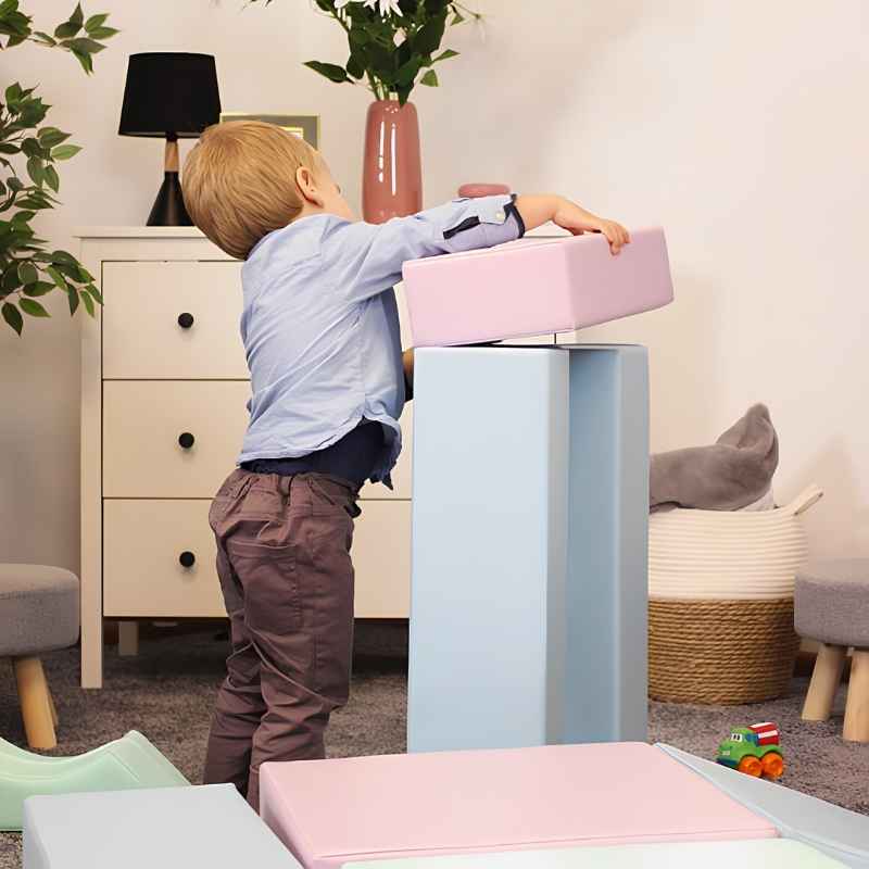 A toddler boy lifting a foam shape from the IGLU Foam Play Set Creativity in Light Pastel, developing fine motor skills
