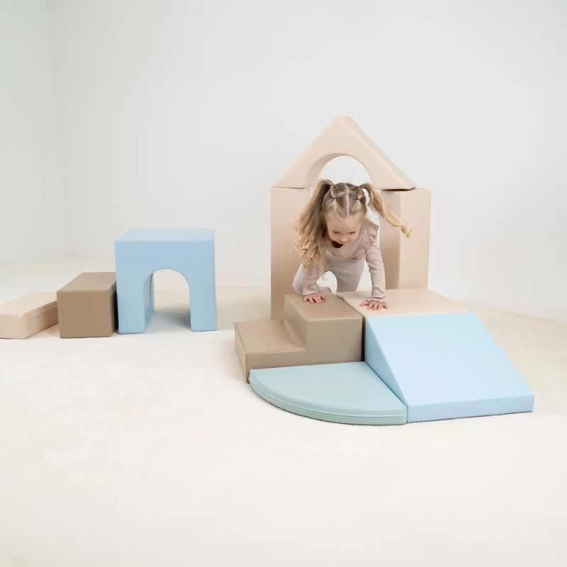 A toddler girl crawling through the arch of the IGLU Foam Play Set Creativity during imaginative and active play