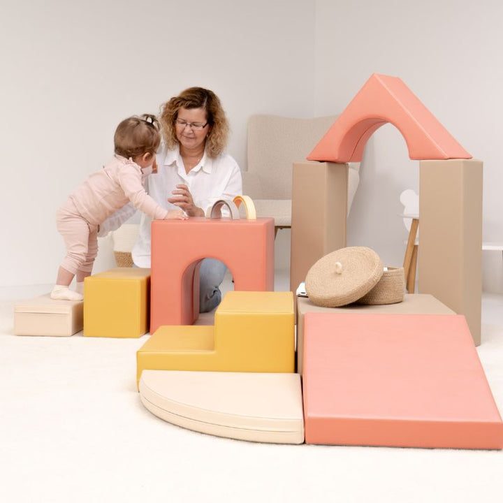 Baby stepping up to the tunnel cube of the IGLU Foam Play Set - Creativity, with the arch on pillars completing the soft play set