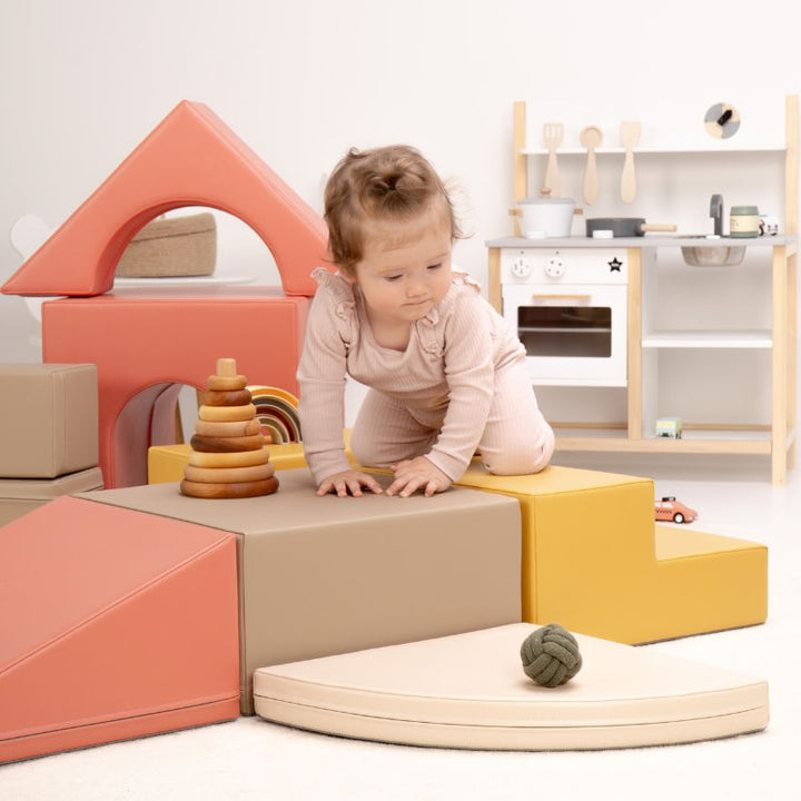 Close-up of a baby crawling across the top of the IGLU Foam Play Set - Creativity, toddler climbing toys with a wipe-clean finish