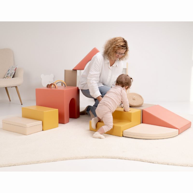 Baby crawling up the steps of the IGLU Foam Play Set - Creativity with a caregiver close by in a home playroom