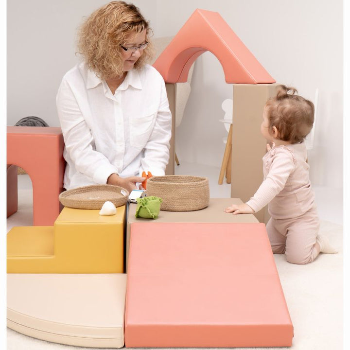Baby kneeling beside the ramp and platform of the IGLU Foam Play Set - Creativity while playing with a caregiver