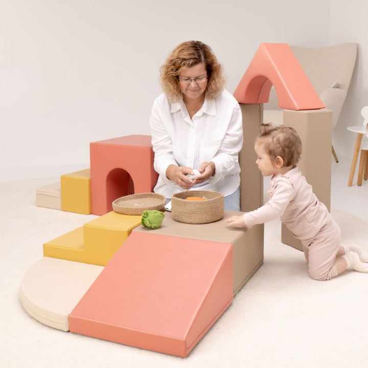 Close-up of a baby practicing pull-to-stand against a foam climbing block from the IGLU Foam Play Set - Creativity