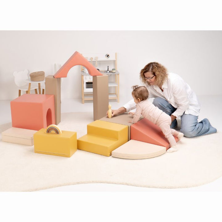 Caregiver guiding a baby up the foam ramp of the IGLU Foam Play Set - Creativity during active baby soft play