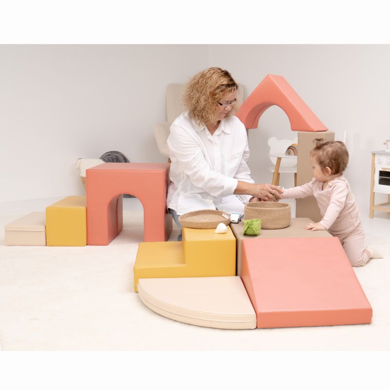 Baby reaching toward a basket on the IGLU Foam Play Set - Creativity, a baby soft play set that supports early motor skills