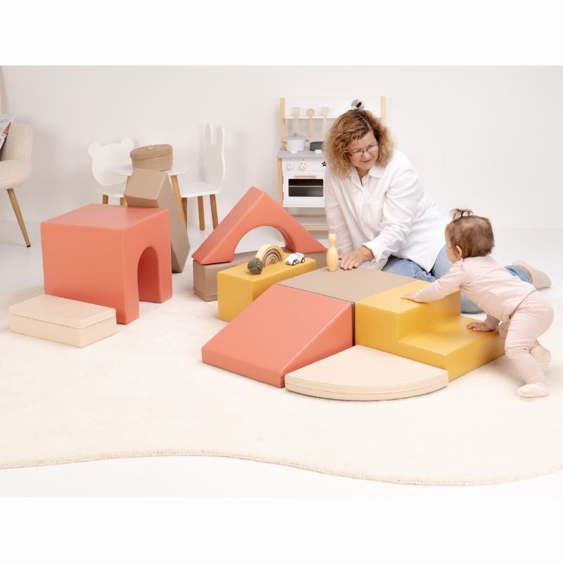 Caregiver and baby exploring a reconfigured IGLU Foam Play Set - Creativity, showing how the foam climbing blocks rearrange freely