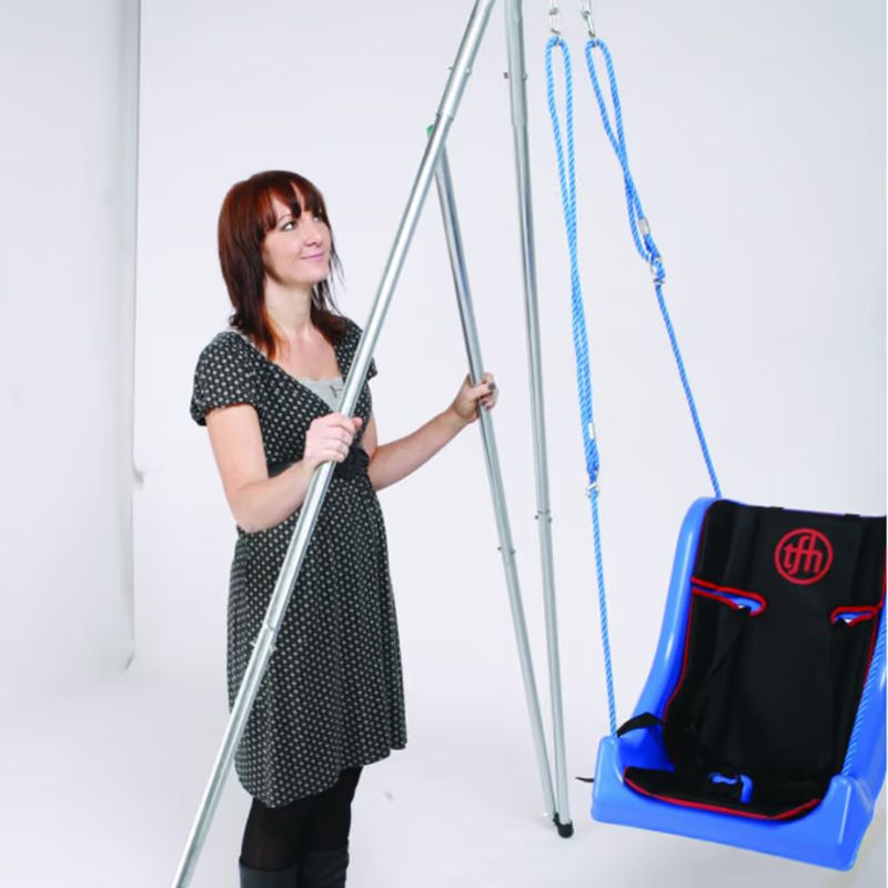 TFH Foldaway Swing Frame shown at full height beside a bucket swing seat, illustrating the scale of this portable vestibular swing stand