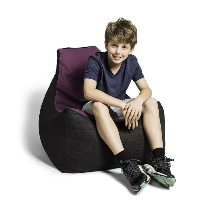 A boy sits comfortably in the Jaxx Pixel gaming bean bag chair in purple, a low seat for kids' reading corners