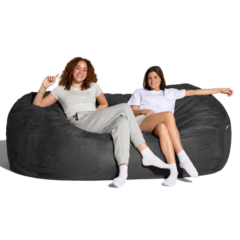 Two people relaxing on the Jaxx 7 ft giant bean bag chair in black microsuede, family seating for calm corners and living rooms
