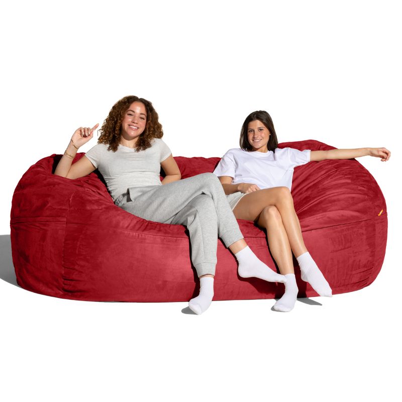 Two people lounging on the Jaxx 7 ft giant bean bag chair in cinnabar microsuede, family seating for living rooms