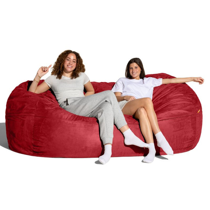 Two people lounging on the Jaxx 7 ft giant bean bag chair in cinnabar microsuede, family seating for living rooms