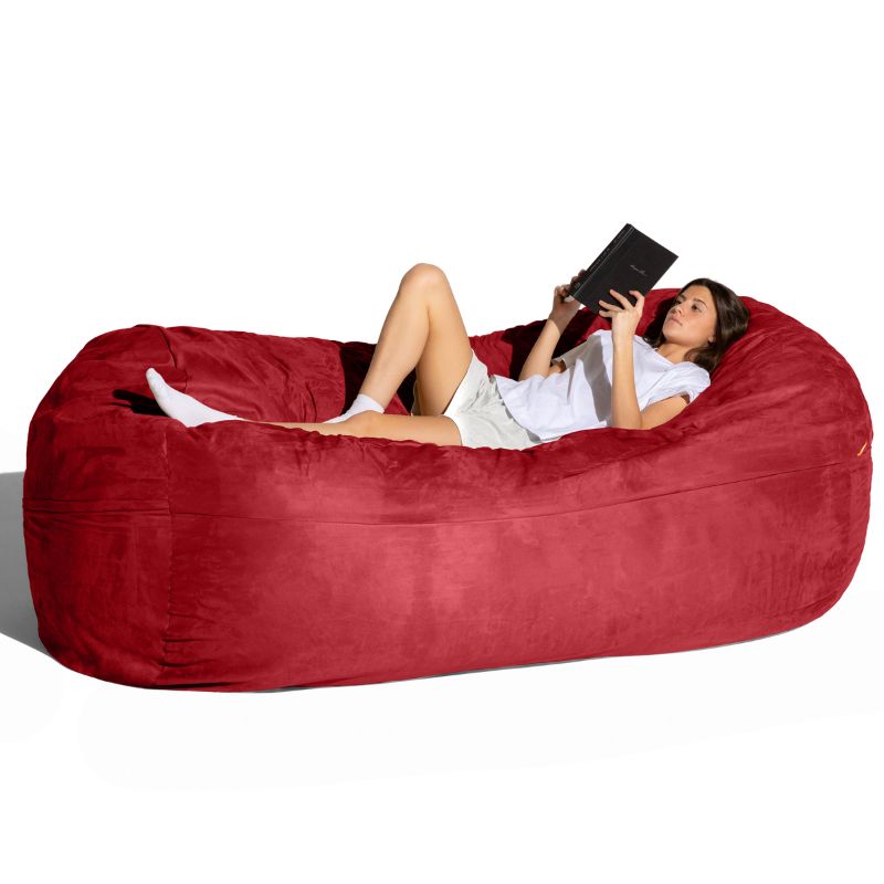 Woman reading on the Jaxx 7 ft giant bean bag chair in cinnabar microsuede, an oversized lounger for living rooms