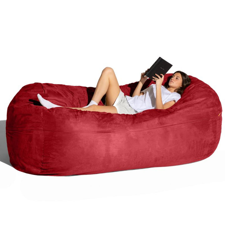 Woman reading on the Jaxx 7 ft giant bean bag chair in cinnabar microsuede, an oversized lounger for living rooms