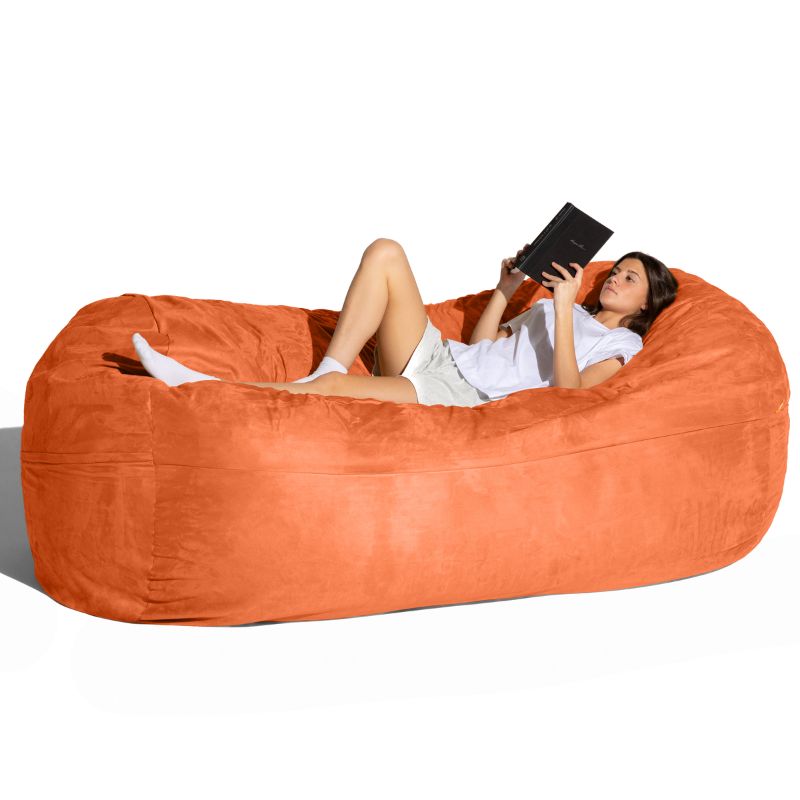 Woman reading on the Jaxx giant bean bag chair in mandarin microsuede for family and sensory spaces