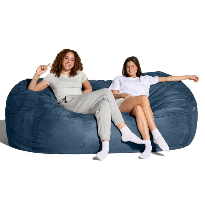 Two people relaxing on the Jaxx 7 ft giant bean bag chair in navy microsuede for calm corners and living rooms
