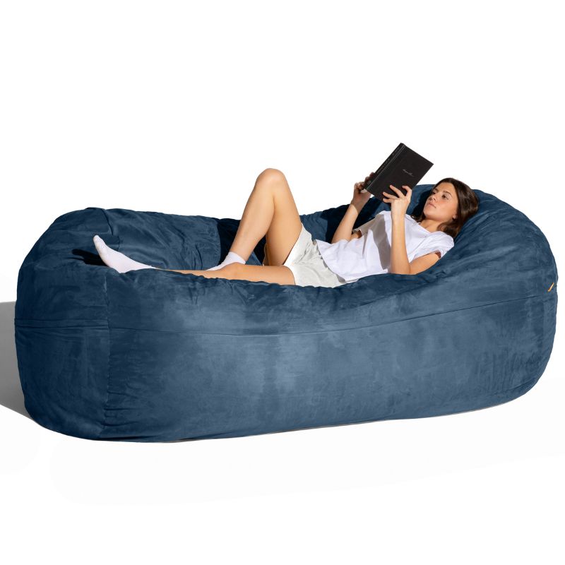 Woman reading on the Jaxx 7 ft giant bean bag chair in navy microsuede for calm corners and living rooms