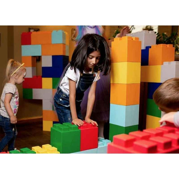 Children building colourful towers with EverBlock giant building blocks during indoor group STEM play
