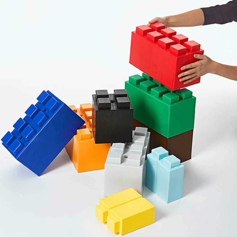  A hand stacking EverBlock giant building blocks, showing the modular pressure-fit design used in classroom STEM sets