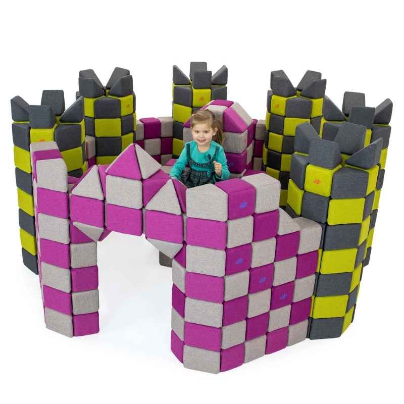 Child inside a castle fort built from JollyHeap giant magnetic building blocks in magenta, yellow-green and grey