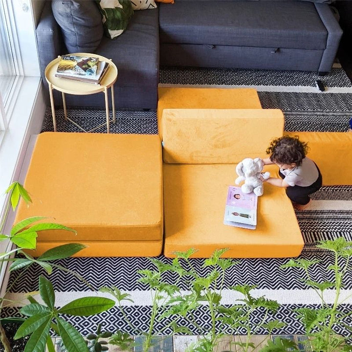 Top-down view of child playing on Go Coconut - The Coconut showing the full surface area of the modular CertiPUR-US certified foam play couch used for creative building and sensory exploration