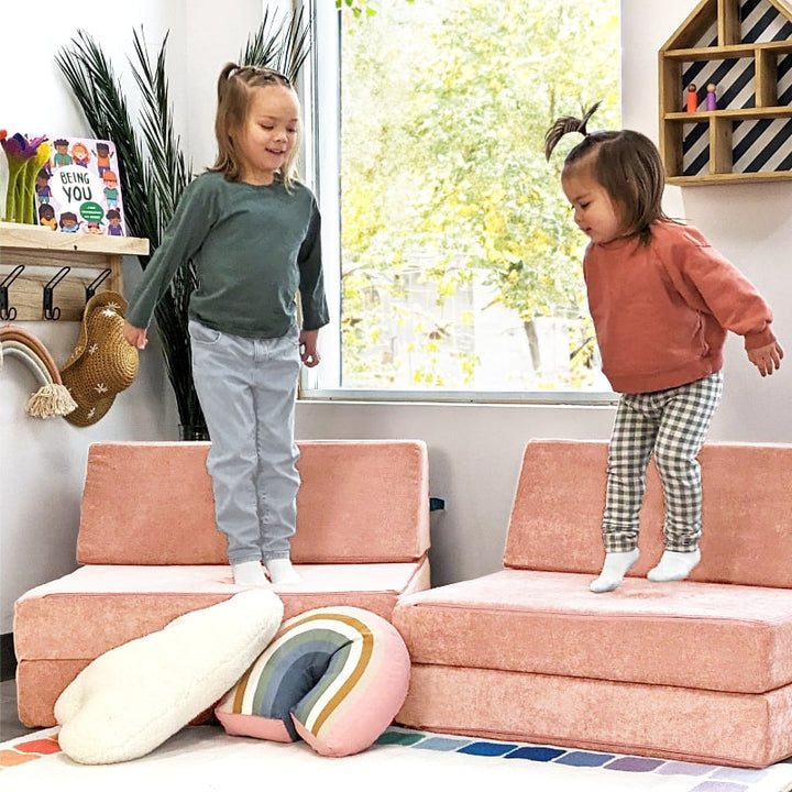 Two children actively playing on the Go Coconut Half Coconut in Peach Party, demonstrating collaborative sensory and motor play