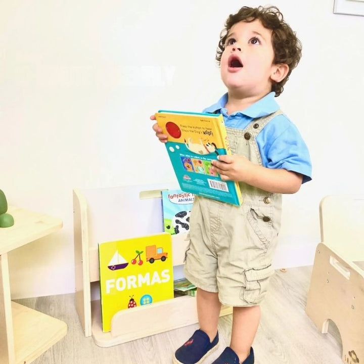 Child actively reading a book chosen from the Sapiens Child Guava Montessori Bookshelf, showing the independence and early literacy engagement the forward-facing display design supports