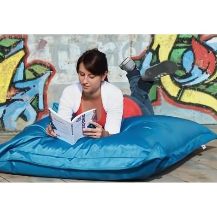 Adult reading on the HABA Pro Turquoise Bean Bag Cushion indoors, demonstrating its use as a sensory lounger and quiet corner seating option