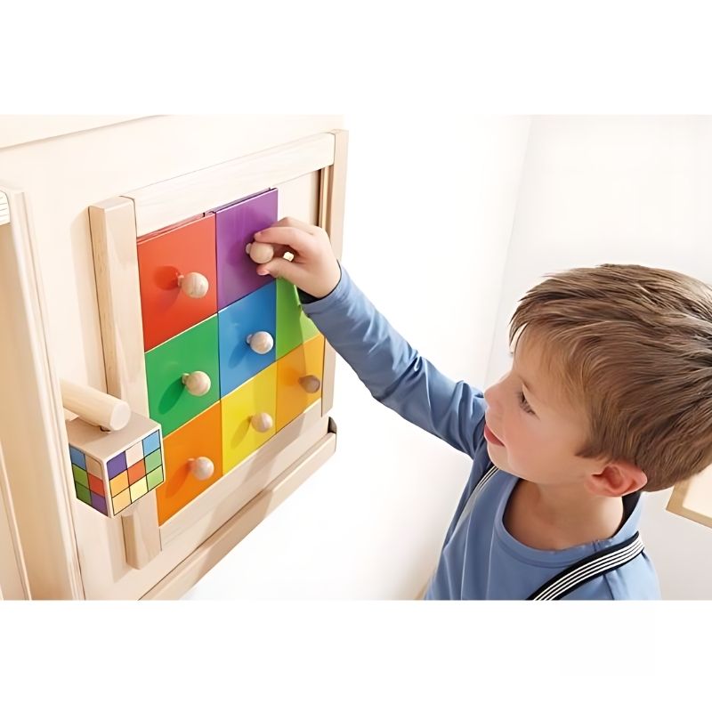 Child engaging with the HABA Pro Colorful Squares sensory wall activity, sliding wooden squares to match the rotating cube pattern