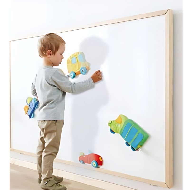HABA Pro Whiteboard Wall Panel in use by a child, showing the magnetic dry-erase surface and birch wood frame in an active learning setting