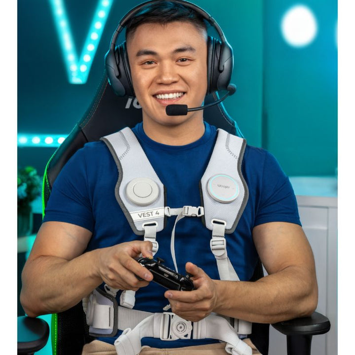 Gamer in a gaming chair with a headset and controller wearing the white Woojer Vest 4 haptic vest, a haptic gaming vest for full-body sound