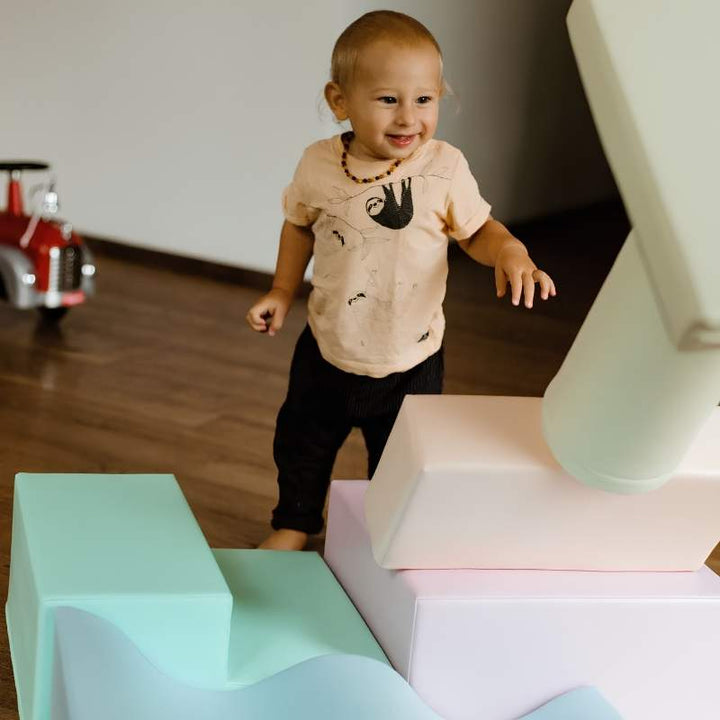 Toddler walking toward the IGLU Explorer Soft Play Set foam shapes in a pastel colourway