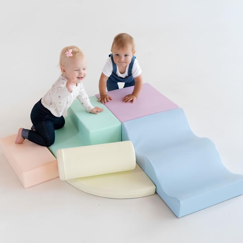 Two toddlers playing on the IGLU Explorer Soft Play Set in a pastel colourway, climbing the step and platform