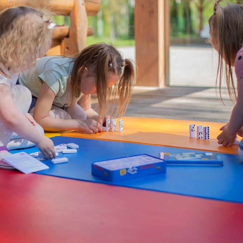 Three children arranging the IGLU 5-Piece Foam Soft Play Mat Set for active domino-style play and gross motor development