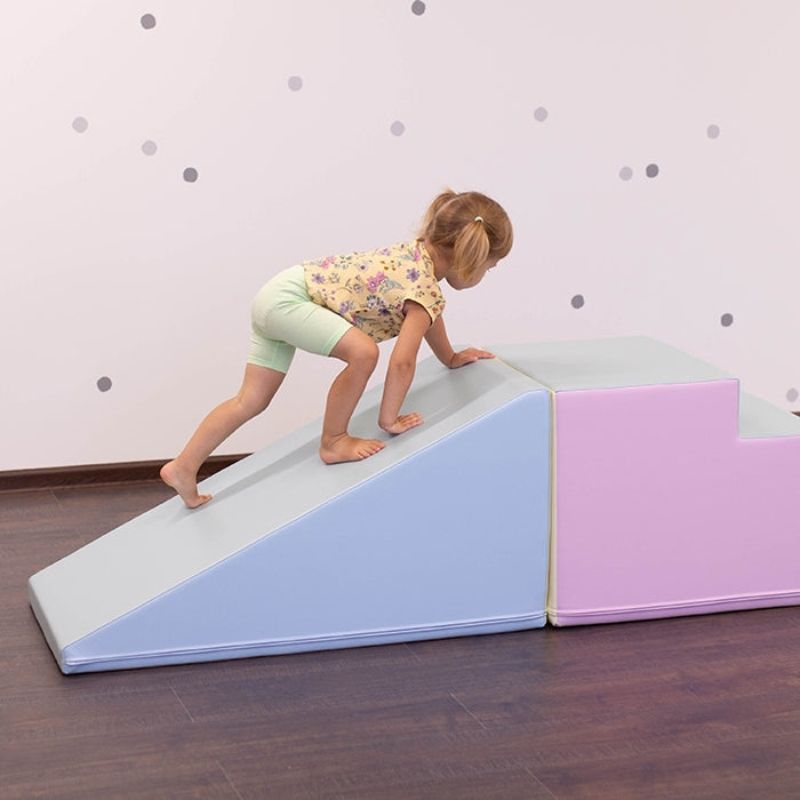 Toddler playing on IGLU Soft Play Mega Fun Slider in Light Pastel colourway, indoor foam climbing set for active development