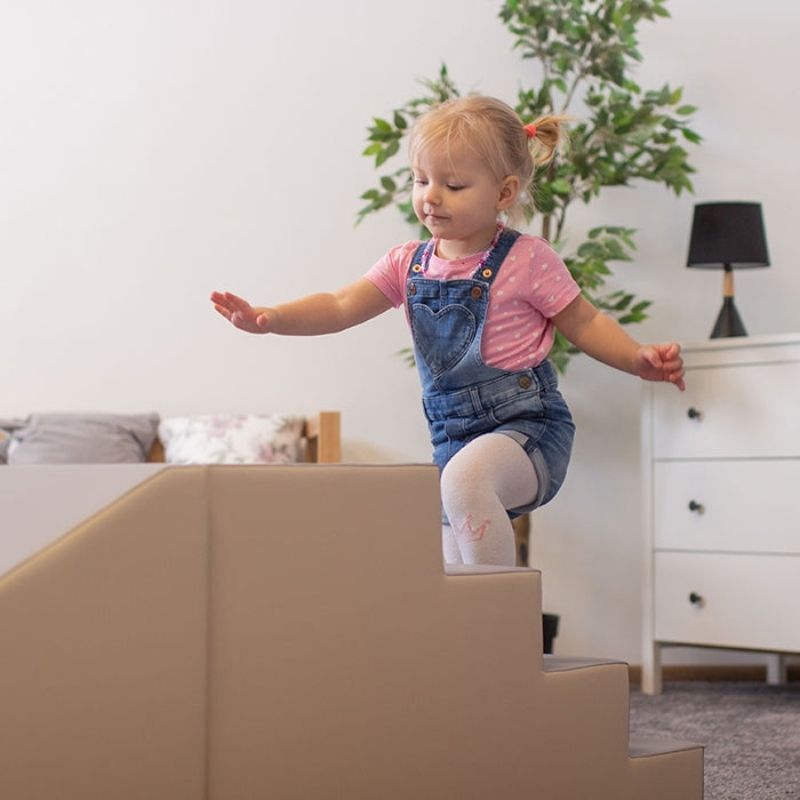 Child climbing foam steps on the IGLU Mega Fun Slider indoor soft play set, developing balance and coordination