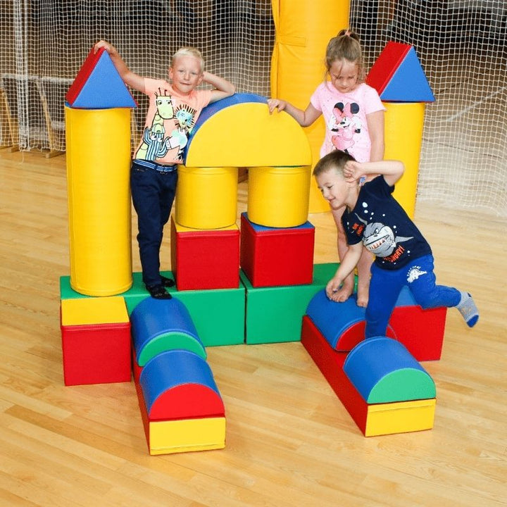 Children actively climbing and crawling through the IGLU Soft Play Fortress foam building block set in multi-colour, showing motor skill development through play