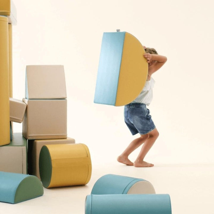 Child at the rear of the IGLU Soft Play Fortress Set in turquoise, showing the full foam block structure height and climbing surfaces