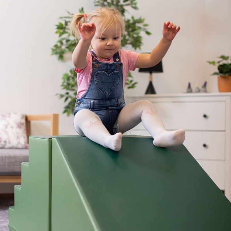 IGLU Soft Play Mega Fun Slider step and slide foam climbing set with child actively sliding, showing gross motor play in action