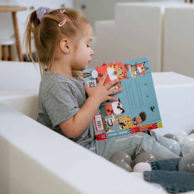 Child settled in the IGLU Soft Play Party Set reading, showing how the foam soft play set supports calm, independent activity as well as active play
