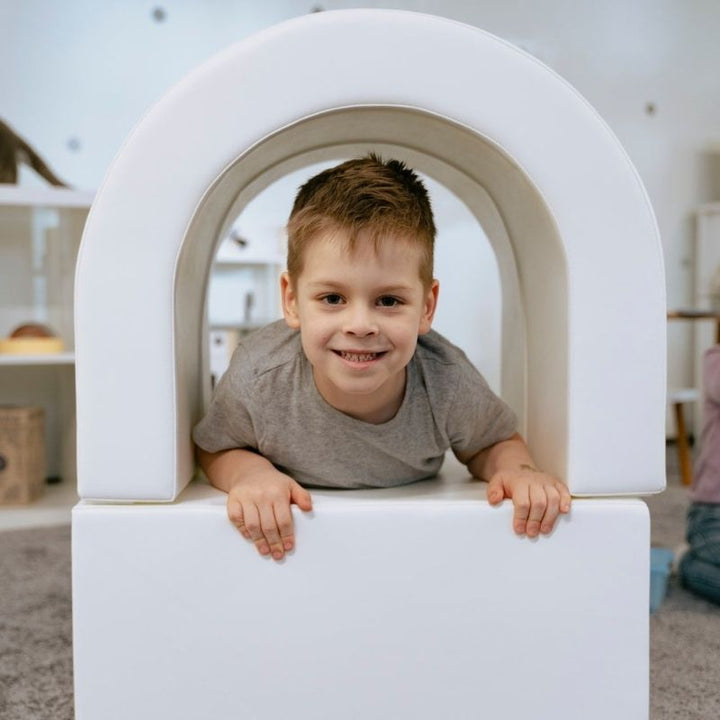 Boy crawling through the tunnel from the IGLU Soft Play Party Set, foam tunnel play supporting gross motor and sensory exploration