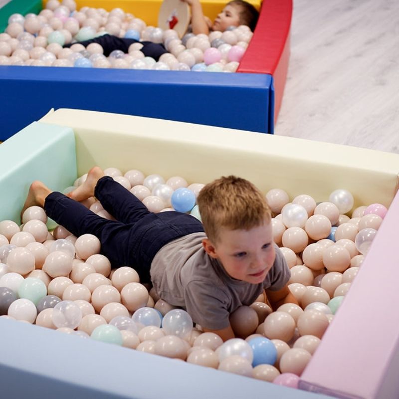 Child playing in IGLU Soft Play Square Ball Pit in light pastel colour, a foam ball pit ideal for toddler sensory development