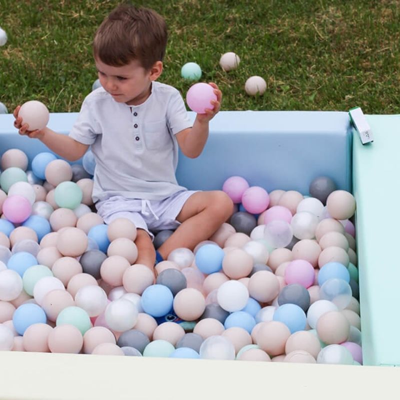 Child engaged in active ball pit play in IGLU Soft Play Square Ball Pit pastel colourway, supporting sensory and motor development