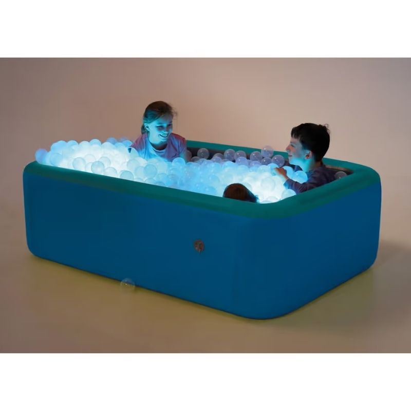 Two children playing inside the TFH Illuminated Inflatable Ball Pool, its clear balls glowing blue from the LED lights for immersive sensory play