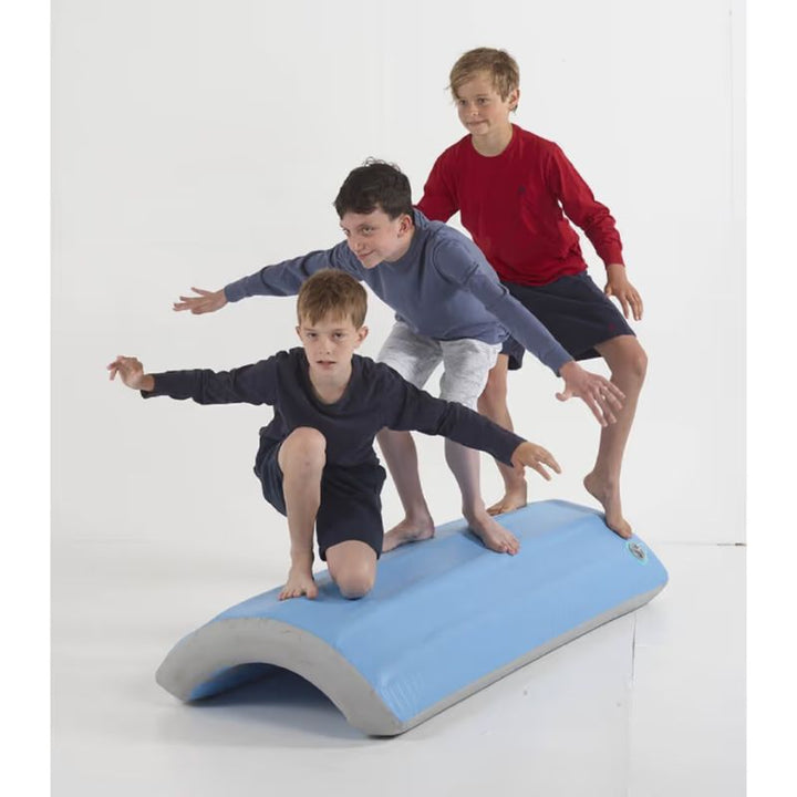 TFH Inflatable Body Rocker flipped over as a balance surface, with three children standing on it to build core strength and stability