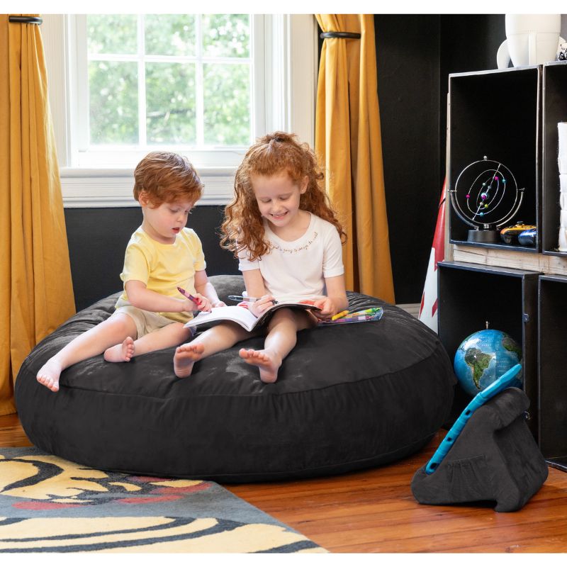 Two children reading together on a black Jaxx Cocoon 4ft kids bean bag chair, a versatile sensory crash pad