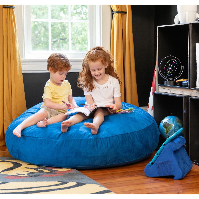 Two children reading together on a blue Jaxx Cocoon 4ft kids bean bag chair, a sensory crash pad for kids' rooms